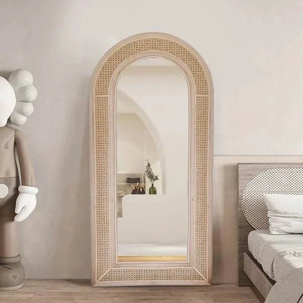 Boris Mirror with pine wood frame and rattan in modern arched boho design in bedroom setting